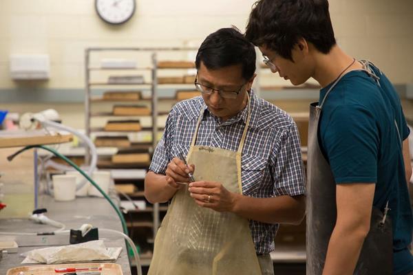 Dr. Wan Yang, left, shows research student Ziyue Ju how to properly label and cut rock samples for analysis. Sam O'Keefe/Missouri S&T