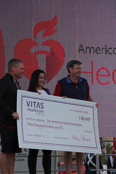 Natalia Hernandez, VITAS Healthcare Regional Director of Market Development, presents a check for $50,000 from VITAS in Lake and Sumter counties to Marlin Hutchens (L) and David Cross (R), both Greater Orlando American Heart Association board members, during Saturday’s Heart Walk Greater Orlando. The grant funds education and awareness initiatives about cardiovascular disease, risk and prevention.