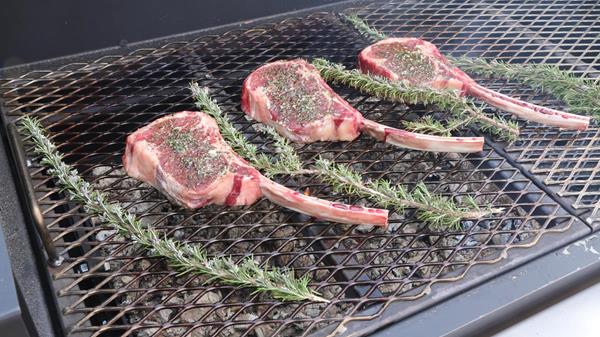 Wood-grilled beef Tomahawk steaks with blue cheese butter being prepared during taping of Project Smoke season three