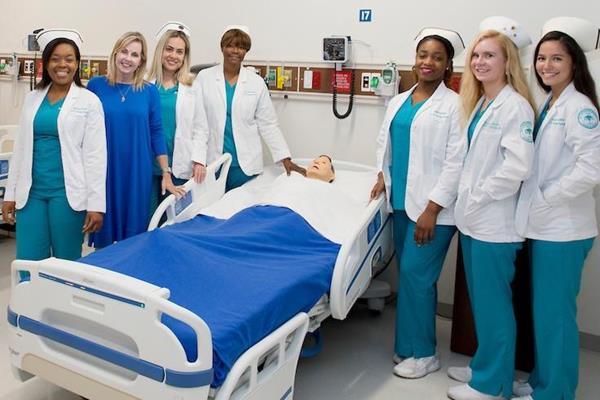 NSU bachelor of nursing students and Marcie Rutherford (second from left), dean of the Ron and Kathy Assaf College of Nursing. The caps the students are wearing are historic, dating back to the 1930s – in honor of Nurses’ Week. (Nurse caps courtesy of Health Museum of the Health Professions Division, Nova Southeastern University)