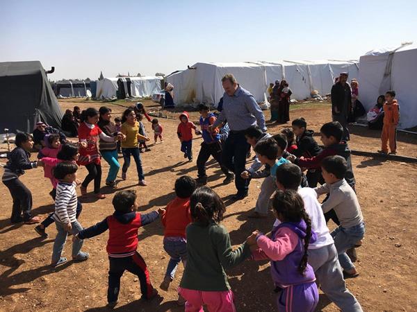 URI members in Jordan work with Syrian children at a refugee camp, helping them regain a sense of normalcy amidst the crisis.