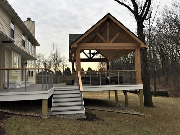 Archadeck of Chicagoland's award winning project in the room/porch category is a dramatic open porch with a spacious TimberTech low maintenance/composite deck. It features a high vaulted ceiling for shade with a faux gable finish and large timbers. 