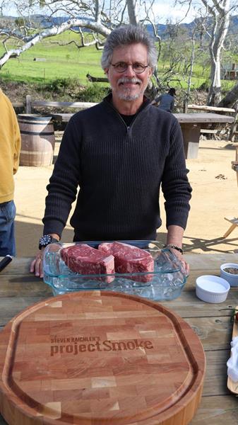 Steven Raichlen preparing cherry-smoked strip steak with cutting board sauce on the set of Project Smoke season three