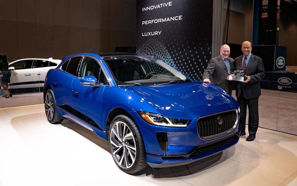 Standing next to the Jaguar I-PACE at the 2019 Chicago Auto Show, MotorWeek creator and host John Davis (right) presents the Drivers' Choice "Best of the Year" Award to Joachim "Joe" Eberhardt, president of Jaguar Land Rover North America LLC at Jaguar Land Rover Automotive.