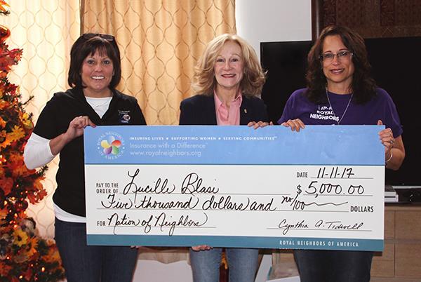 In celebration of the 10th anniversary of its Nation of Neighbors(SM) Program to empower women, Royal Neighbors of America awarded 12 grants totaling $100,000 to recipients across the country. Lucy Blasi, Aurora, Illinois, at right, received $5,000 to expand her volunteer sewing projects that help those in need. Also shown are Royal Neighbors president and chief executive officer Cynthia Tidwell, center, and Tracy Kotecki, who nominated Lucy for the grant, left.
