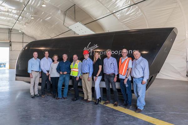 A delegation from the Dallas-Ft Worth Regional Transportation Council with Virgin Hyperloop One's XP-1, the vehicle used to set a historic ​test speed record of nearly 240 miles per hour​ on only 300 meters of acceleration during testing at DevLoop. 