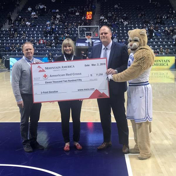 Mountain America presents a $11,250 check to Adam Whitaker and Jennifer Bean, who represented the American Red Cross, at the BYU game on March 2, 2019.