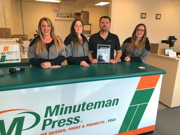 Karen McArthur and Jeff Wereley (middle) own the Minuteman Press design, marketing, and printing franchise in Guelph, Ontario, Canada.