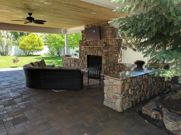 Archadeck of Salt Lake City’s winning hardscape project is a rustic-looking Belgard paver patio with Holland stone in Victorian in shades of gray, brown, and amber. The hardscape also features a stunning outdoor fireplace wrapped in natural-looking Harriston veneer. Granite tops extend out on both sides to add both functionality and privacy, making this an outdoor space perfect for entertaining. 
