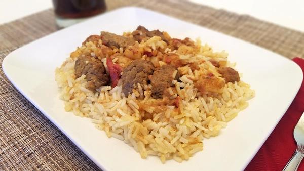 Halal Beef Biryani with Basmati Rice on White Plate on Placemat with Soda and Fork 