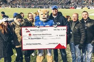 Mountain America employees present a $6,000 check to Adam Whitaker, who represented the American Red Cross, at the BYU game on November 17, 2018.