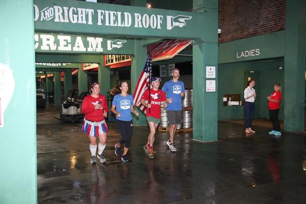 Members of Team Red, White & Blue run Old Glory through Fenway Park in Boston on September 11, 2018 as the flag begins its epic journey across the country to arrive in San Diego on Veterans Day. oldgloryrelay.org