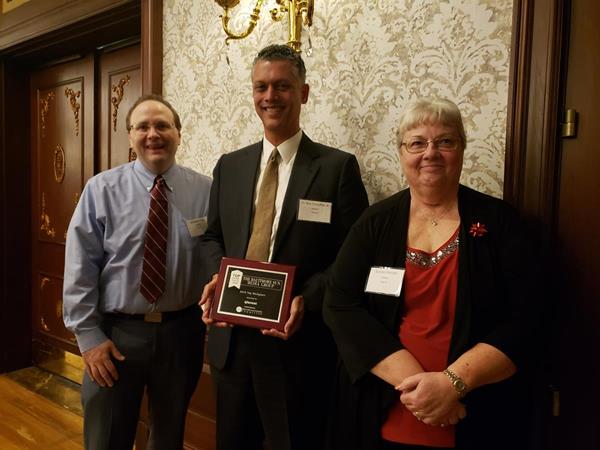 Jonathan Haag, Dr. Ron Forsythe Jr., Phd, and Bonnie Horvath accept the Top Workplaces Award