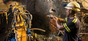 A member of the Titan drilling team operating a drill rig underground at Kipushi