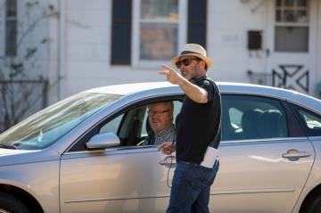 Film director Derrick Borte (standing) talks to lead actor Jim Gaffigan as they prepare to shoot a scene for the movie.