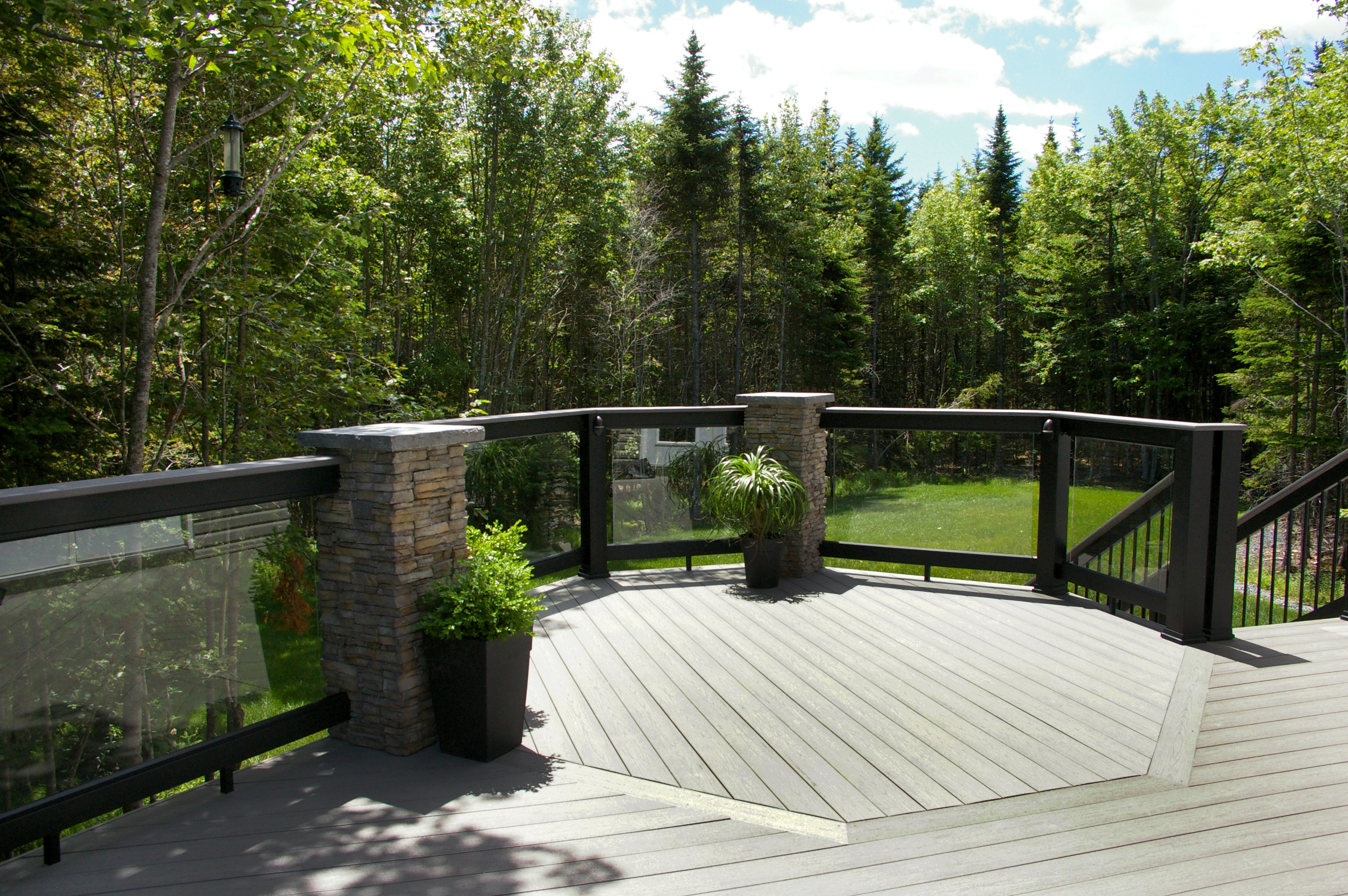 To construct this award-winning deck, Archadeck of Nova Scotia removed and replaced the homeowner's outdated deck with a multi-level entertainment area. Silver Maple TimberTech composite decking is accented with black aluminum railing and glass inlays to maximize their view. Riser lights were added to safely guide residents up and down the steps. 
