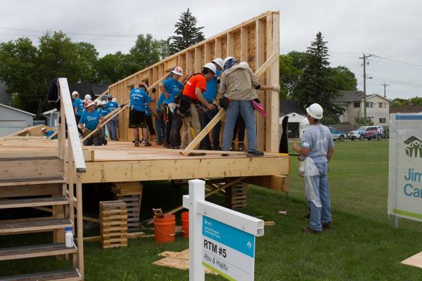 Habitat for Humanity volunteers in Winnipeg, Manitoba, raise the wall of a new Habitat home during Habitat's Jimmy and Rosalynn Carter Work Project in 2017.
