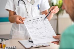 Doctor-receiving-patient-registration-form