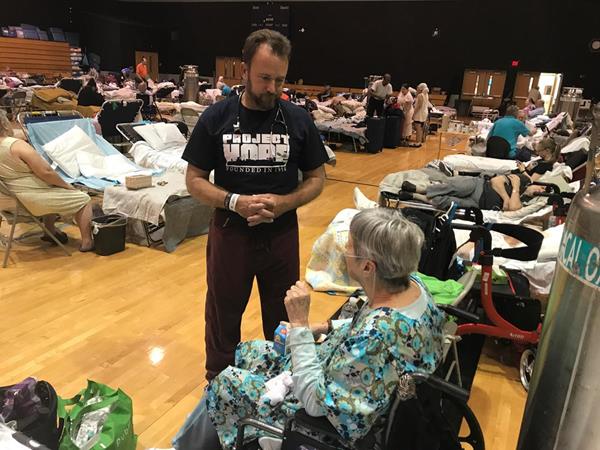 Dr. Kevin Blanton, a geriatric specialist assists the elderly at a shelter in Lee County, Florida
