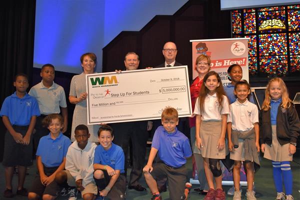 On Oct. 9, Waste Management Director of Communications Dawn McCormick presents Step Up For Students COO Anne White with a $5 million donation at Highlands Christian Academy in Pompano Beach. The donation will provide 744 scholarships for Florida schoolchildren through the Florida Tax Credit Program. Pictured behind the check (left to right) are Waste Management’s Dawn McCormick, Highlands Christian Academy School Administrator Dr. Steve Lawrence, Pompano Beach Mayor Lamar Fisher and Step Up’s Anne White. they are joined by several students from Highlands Christian Academy who are benefiting from the Step Up Scholarship.
