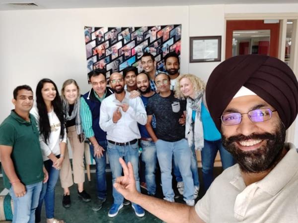 Managing Director Manpreet Singh (right) and the Jaipur team pose with the organization's 
leadership in front of a Traction on Demand banner. 
