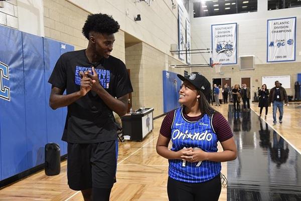 Magic player Jonathan Isaac gives Priann Franco a tour of the AdventhHealth Practice Facility.