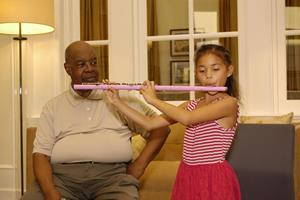 (L) Maurice Mickens - President of Harlem Nights Non-profit Organization with Aydana Cervano playing the flute in at the Scientology Information Center.JPG