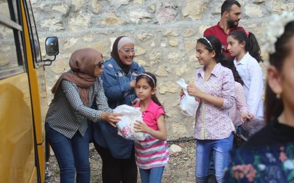 Two Muslim women, who are members of a URI group called Iris Women, distribute much-needed supplies to Syrian refugee families during Ramadan 2018.