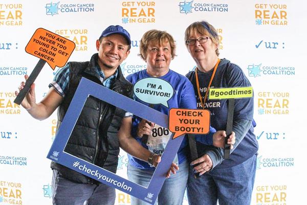 (l-r) Dennis Arrivillaga (caregiver), Diane Bendtsen (colorectal cancer survivor), and Barbara Waters (colorectal cancer survivor) all leaders in COLONTOWN meet in the photo booth at Get Your Rear in Gear - Twin Cities in September 2017.