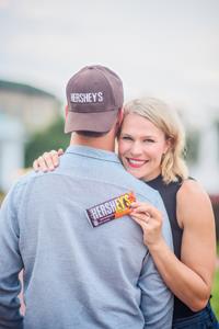 Jenny Ries holding the new HERSHEY'S Milk Chocolate Bar with REESE'S PIECES candy.